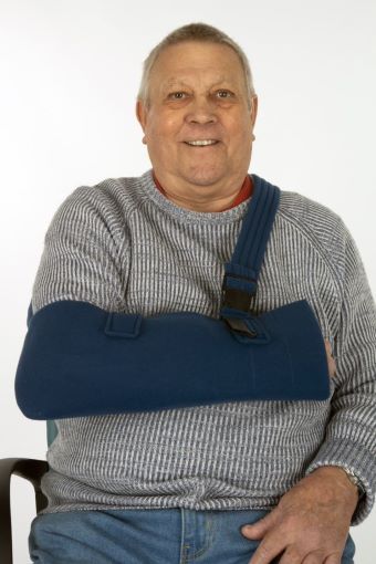 Man wearing a full arm or Polysling arm support