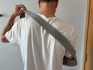 Person adjusting polysling shoulder strap 