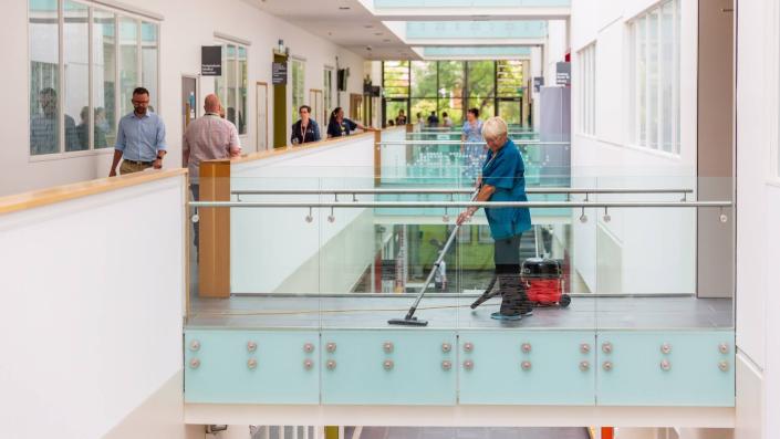 Cleaner using a vacuum in a corridor