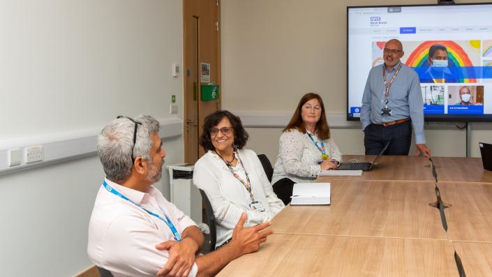 Group meeting at a table with one person presenting