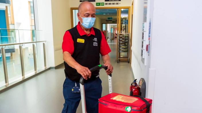 Porter pushing medical products on a trolley