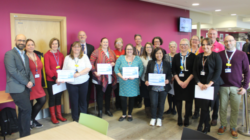 Group of NBT staff holding certificates