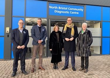 A group of people stand outside a building with a sign reading "North Bristol Community Diagnostic Centre".