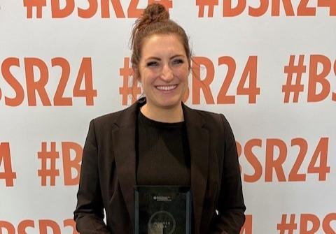Emily-Rose Parfitt is stood smiling holding the BSR award.