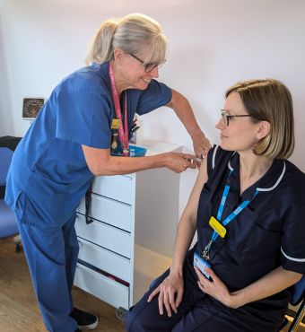 Southmead Hospital's Antenatal Clinic Manager, Cathy Poole, receives her RSV vaccination into her right arm.